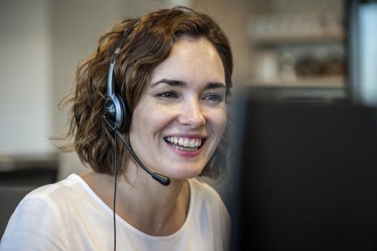 Customer service representative wearing headset in the office